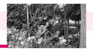 Nazarena and Robert embrace in a garden, with their foreheads touching.